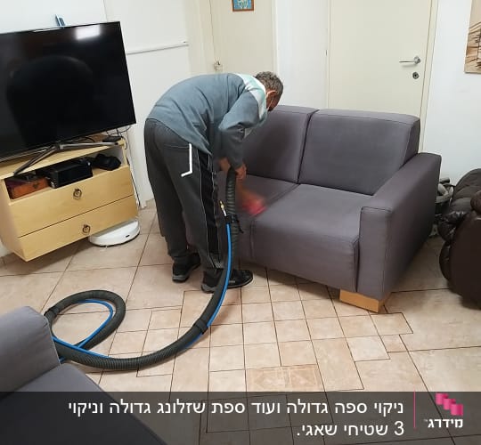 אדם מנקה ספה עם שואב אבק